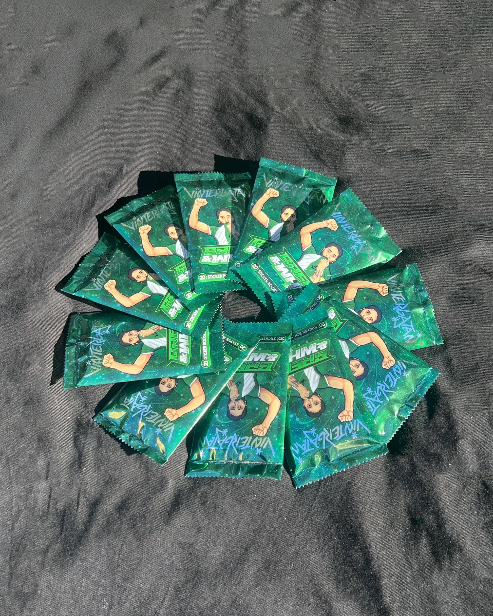 Samling av 10–20 st Green & White Edition Booster-pack från Vintergatan utspridda på svart bakgrund.